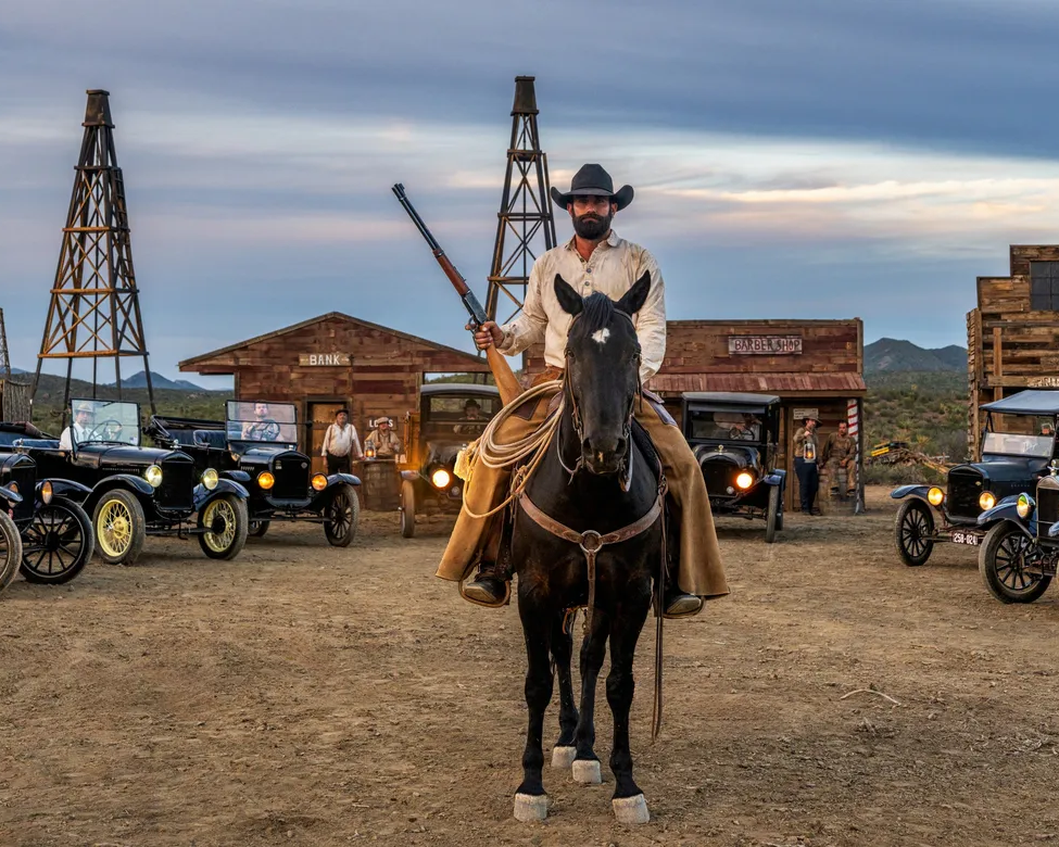 Boom Town by David Yarrow – Fine Art Color Photograph of Cowboy and Vintage Cars in Wild West – Available at Hilton Contemporary Gallery Chicago