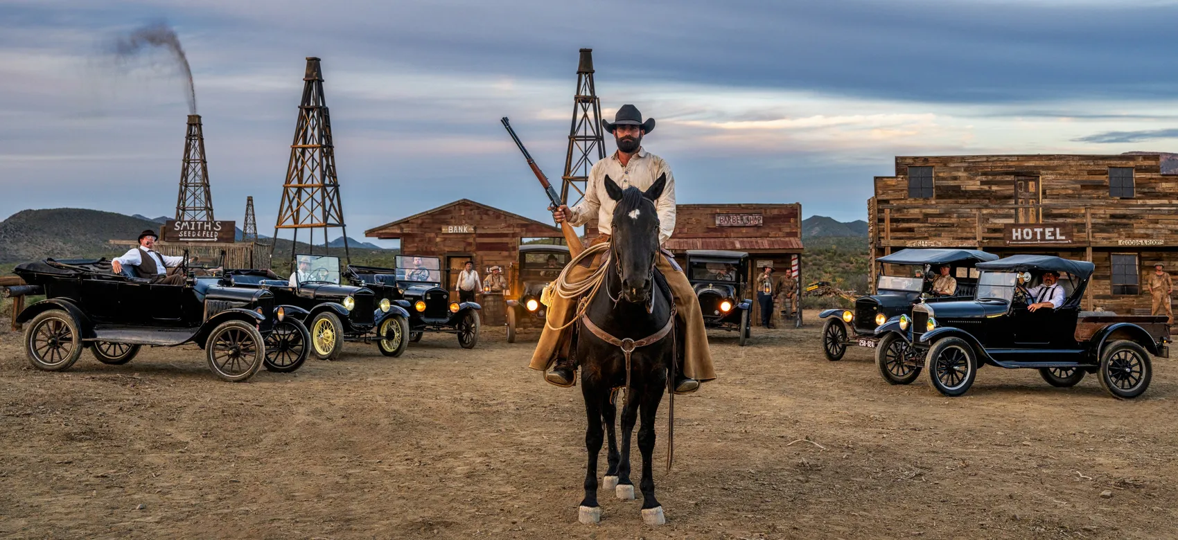 Boom Town by David Yarrow – Fine Art Color Photograph of Cowboy and Vintage Cars in Wild West – Available at Hilton Contemporary Gallery Chicago