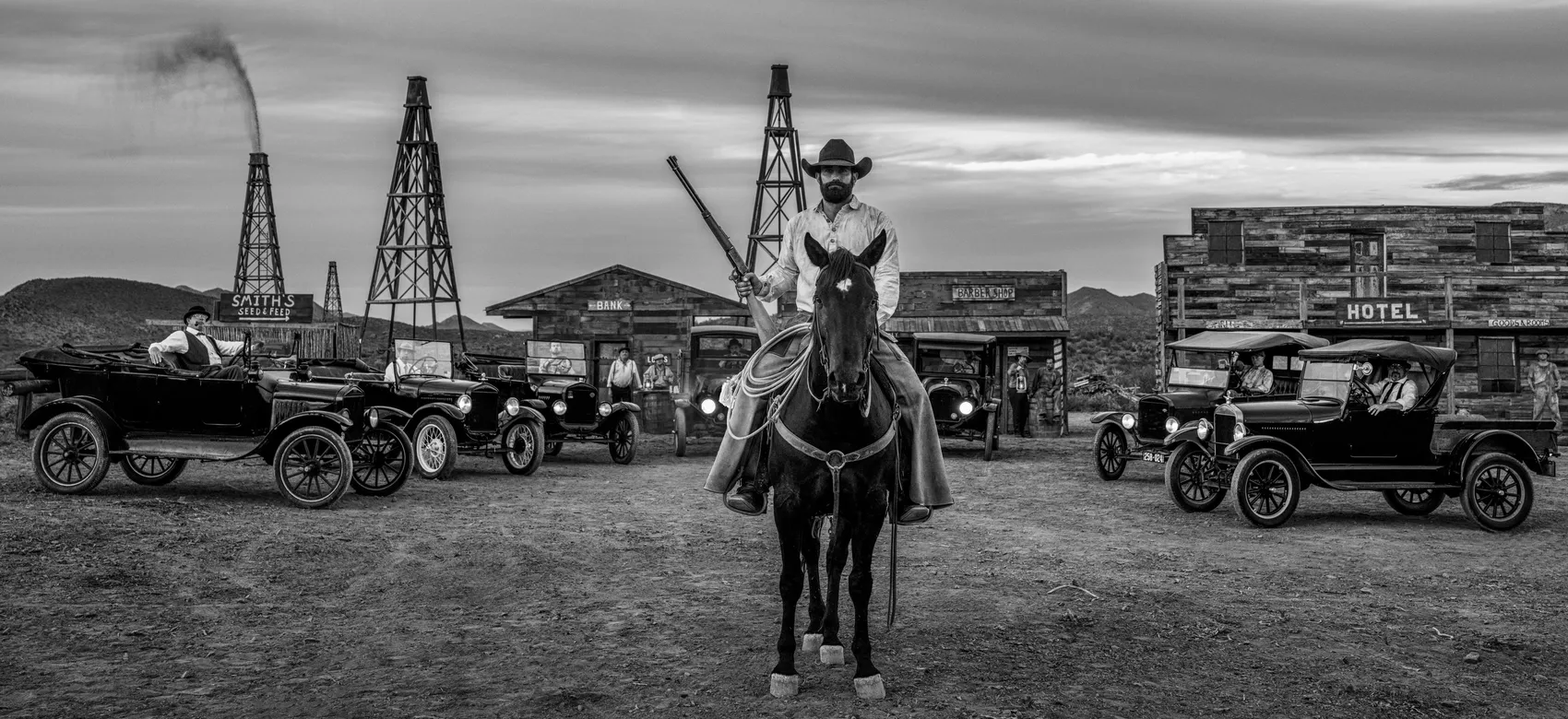 Boom Town by David Yarrow – Fine Art Photograph of Cowboy and Vintage Cars in Wild West – Available at Hilton Contemporary Gallery Chicago
