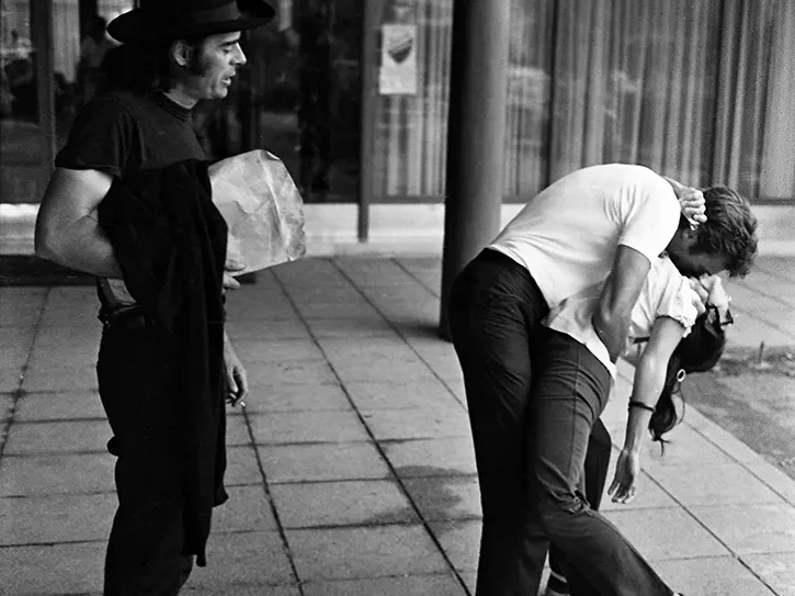 Clint Eastwood behind the scenes of Kelly’s Heroes kissing a woman on set as director Brian G. Hutton watches, Yugoslavia 1969