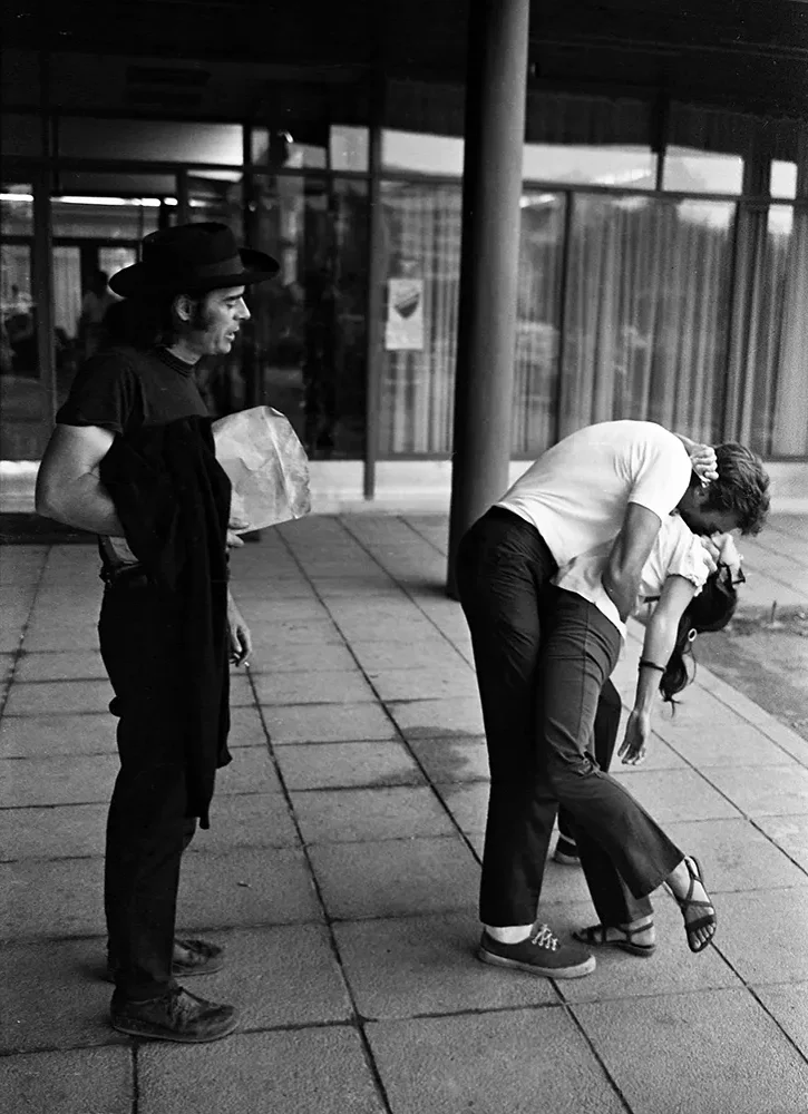 Clint Eastwood behind the scenes of Kelly’s Heroes kissing a woman on set as director Brian G. Hutton watches, Yugoslavia 1969