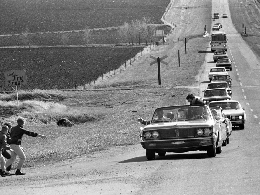 Robert F. Kennedy campaigning in 1968, greeting supporters from his car during the U.S. presidential race