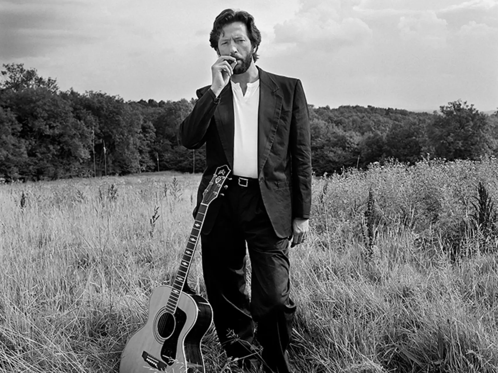 Eric Clapton posing with his guitar near his home in Surrey, photographed by Terry O’Neill in 1993