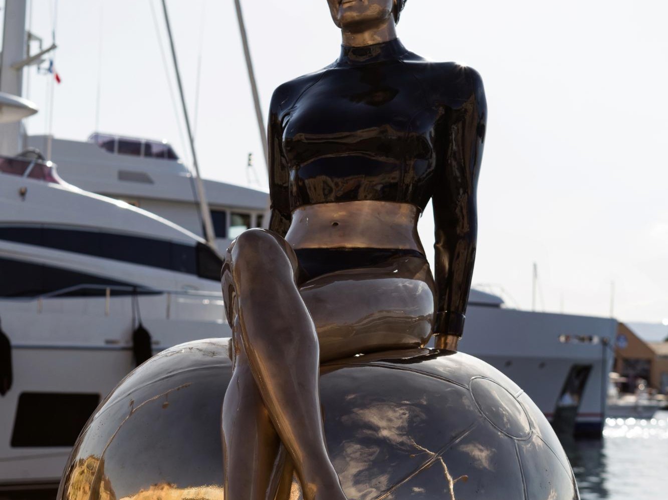 Bibi on the Ball. A hyper-realistic sculpture by Carole Feuerman. Painted Bronze with Polished Bronze Accents. Monumental Scale. 64 x 46 x 34 inches.