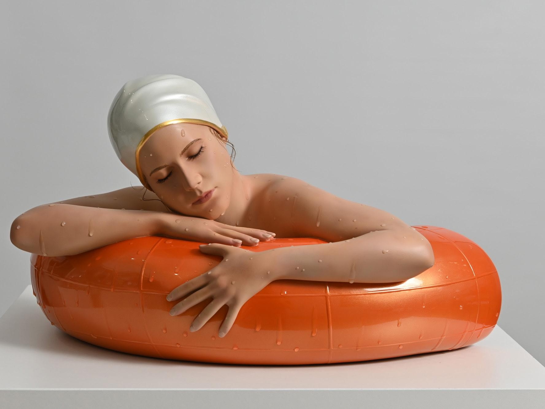 Miniature Serena with Tangerine Tube. A hyper-realistic sculpture by Carole Feuerman. Oil on Resin with Pearl White Cap and Gold Rim. Table Top Scale. 10 x 17 x 8 inches.