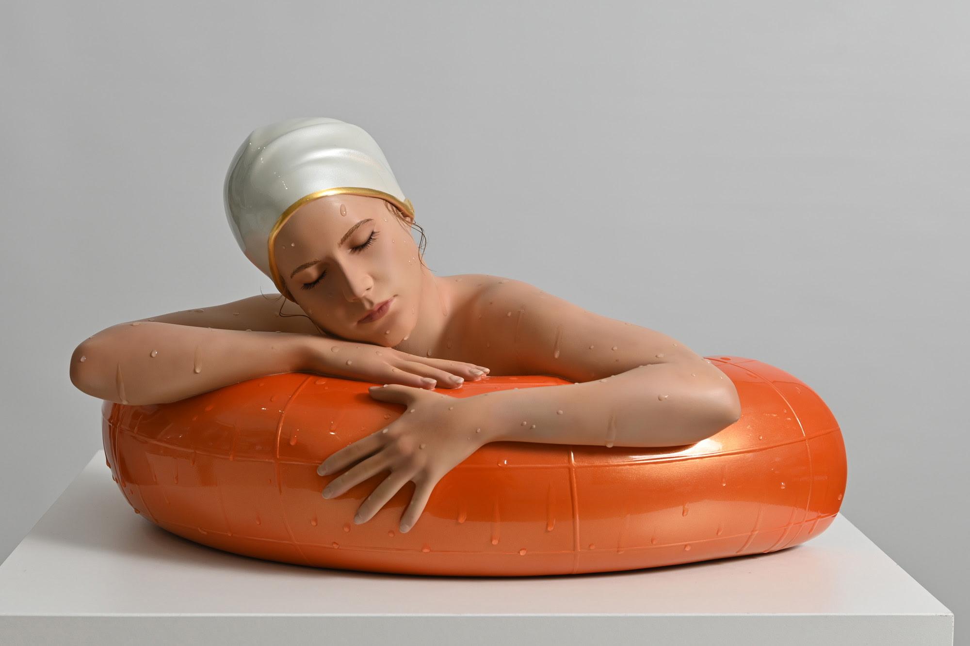 Miniature Serena with Tangerine Tube. A hyper-realistic sculpture by Carole Feuerman. Oil on Resin with Pearl White Cap and Gold Rim. Table Top Scale. 10 x 17 x 8 inches.