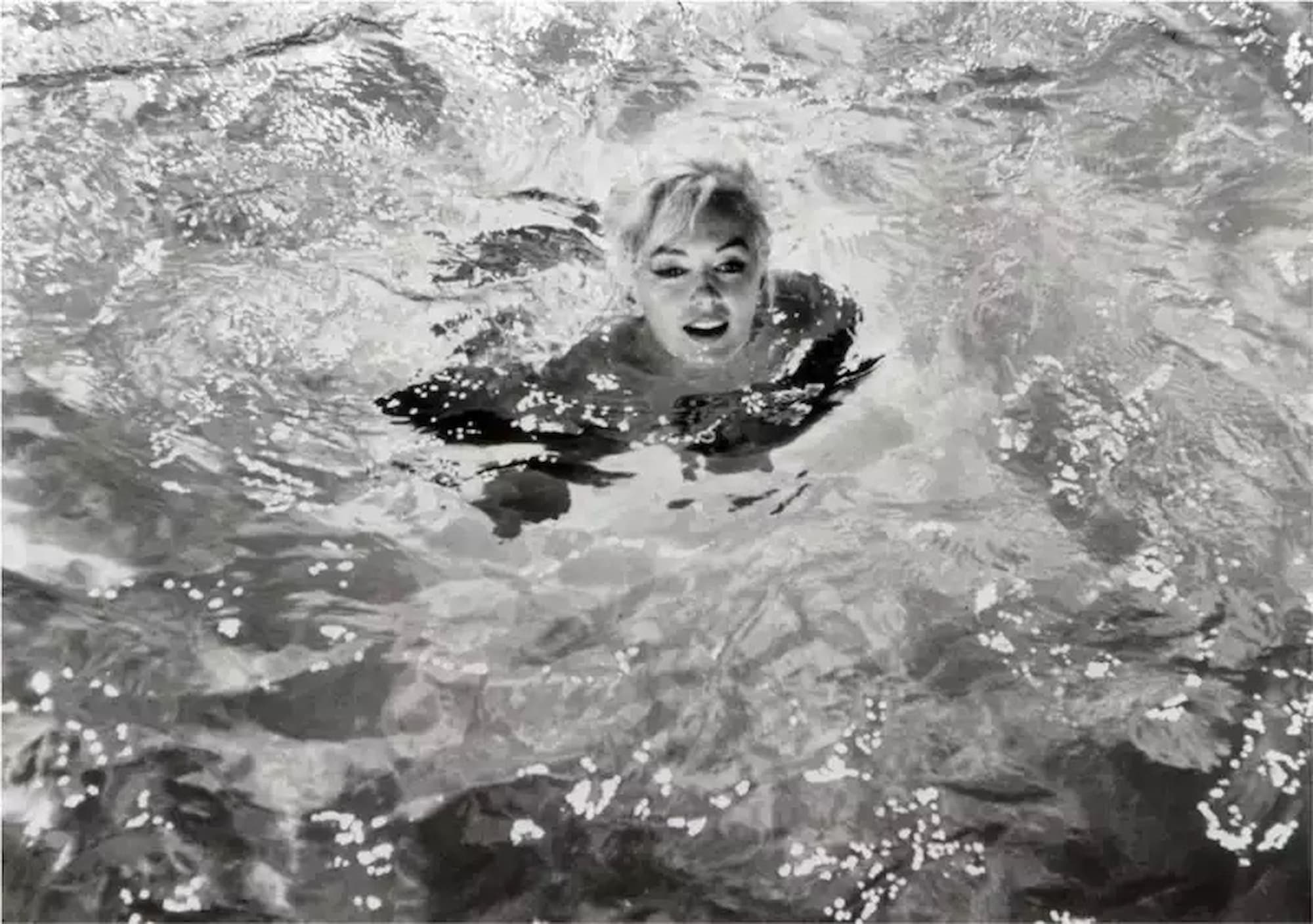 Marilyn Monroe treading water in pool, head above water looking at camera — Marilyn Immersed, 1962, Lawrence Schiller.