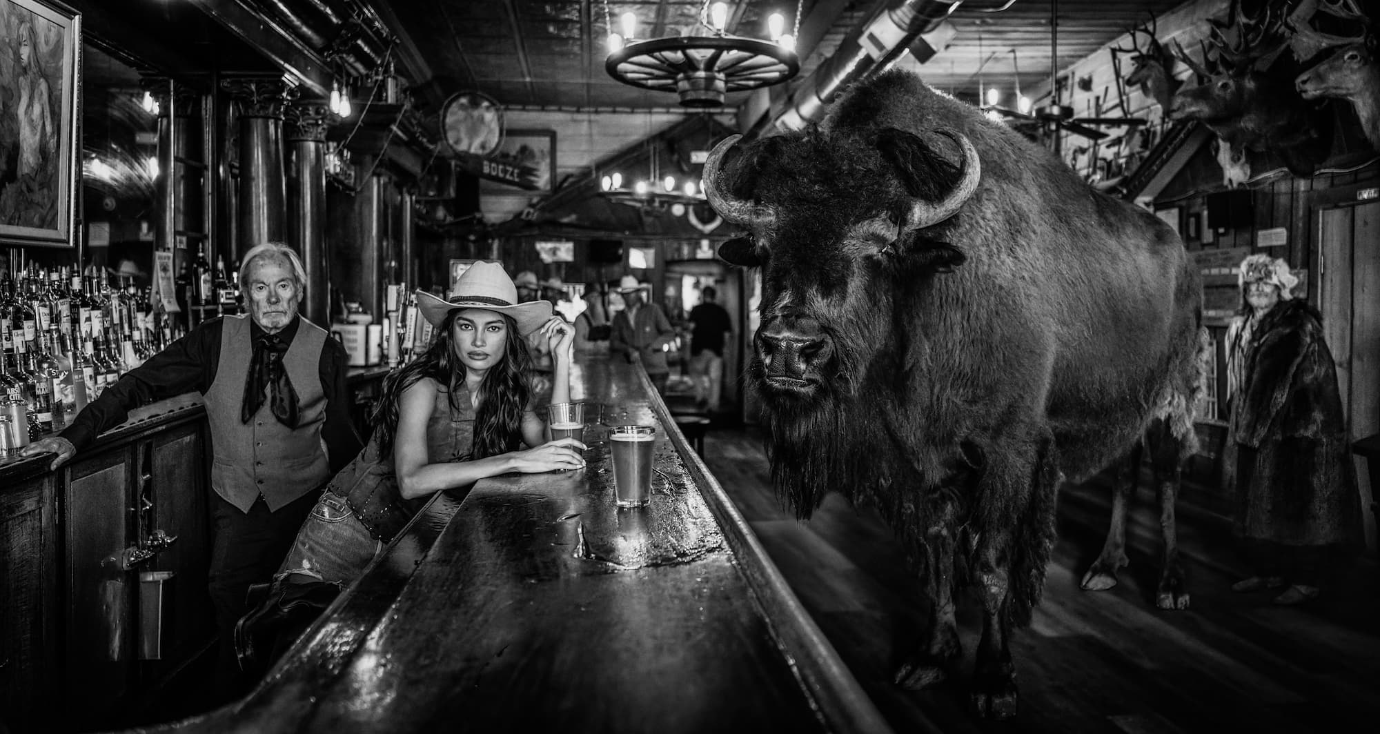 "A Bison Walks into a Bar..." by David Yarrow, Virginia City, Montana, 2026. Black and white photograph.